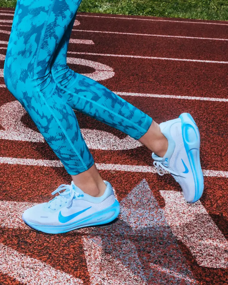 Running shoes and printed leggings mid stride on the track
